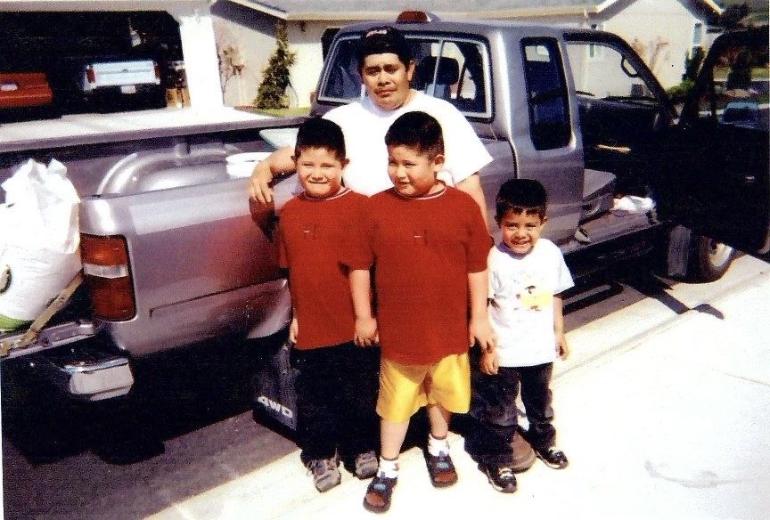 The family's kids standing by the work truck